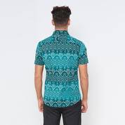 a man showcasing the details on the back of batik shirt in the pattern turquoise anyam