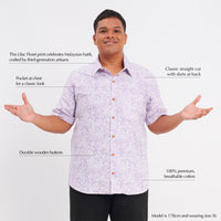 a male model posing in front of a white background while wearing a batik shirt in the pattern lilac pattern