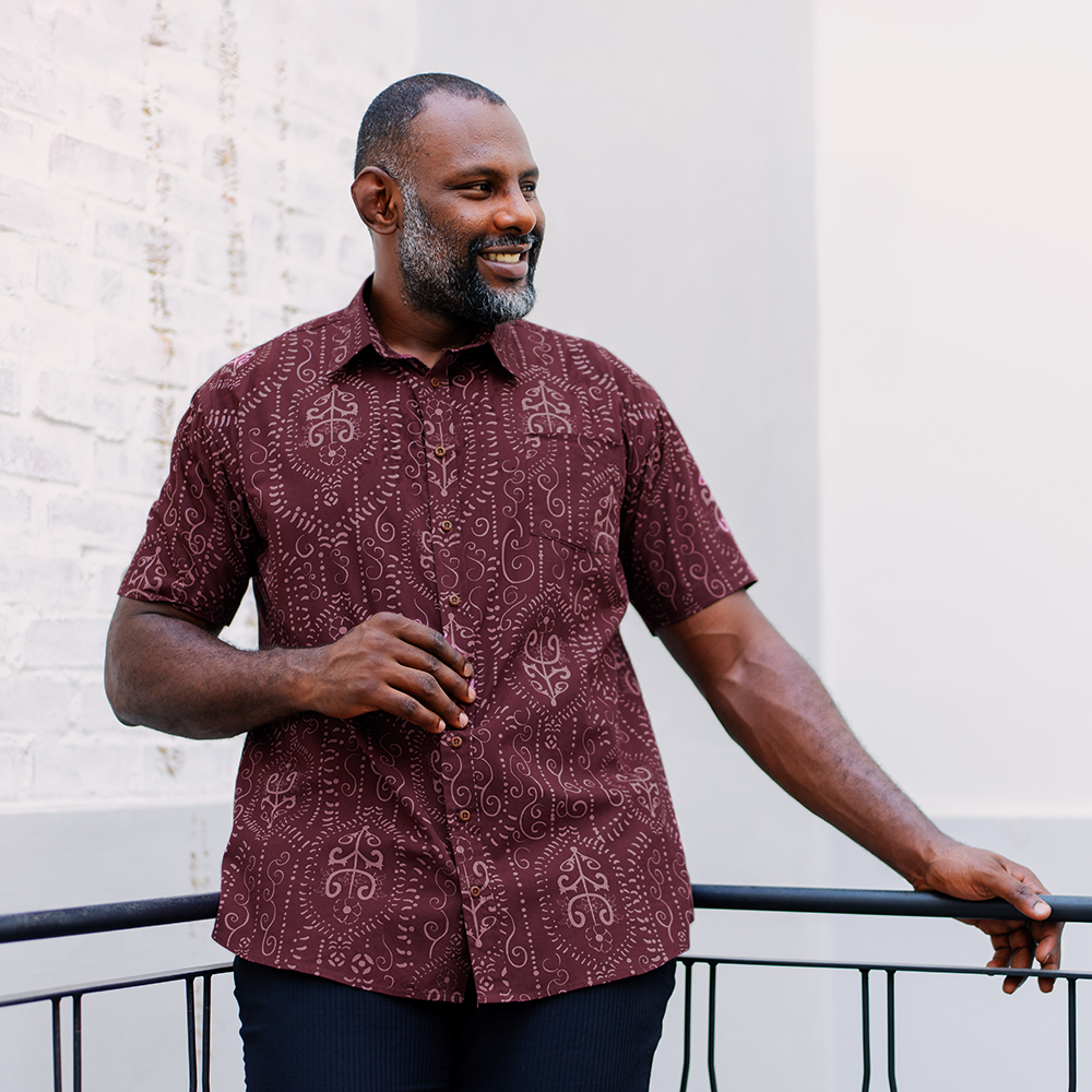 Model wearing Garnet Petola batik shirt outdoors, styled for casual or smart-casual occasions with Southeast Asian flair