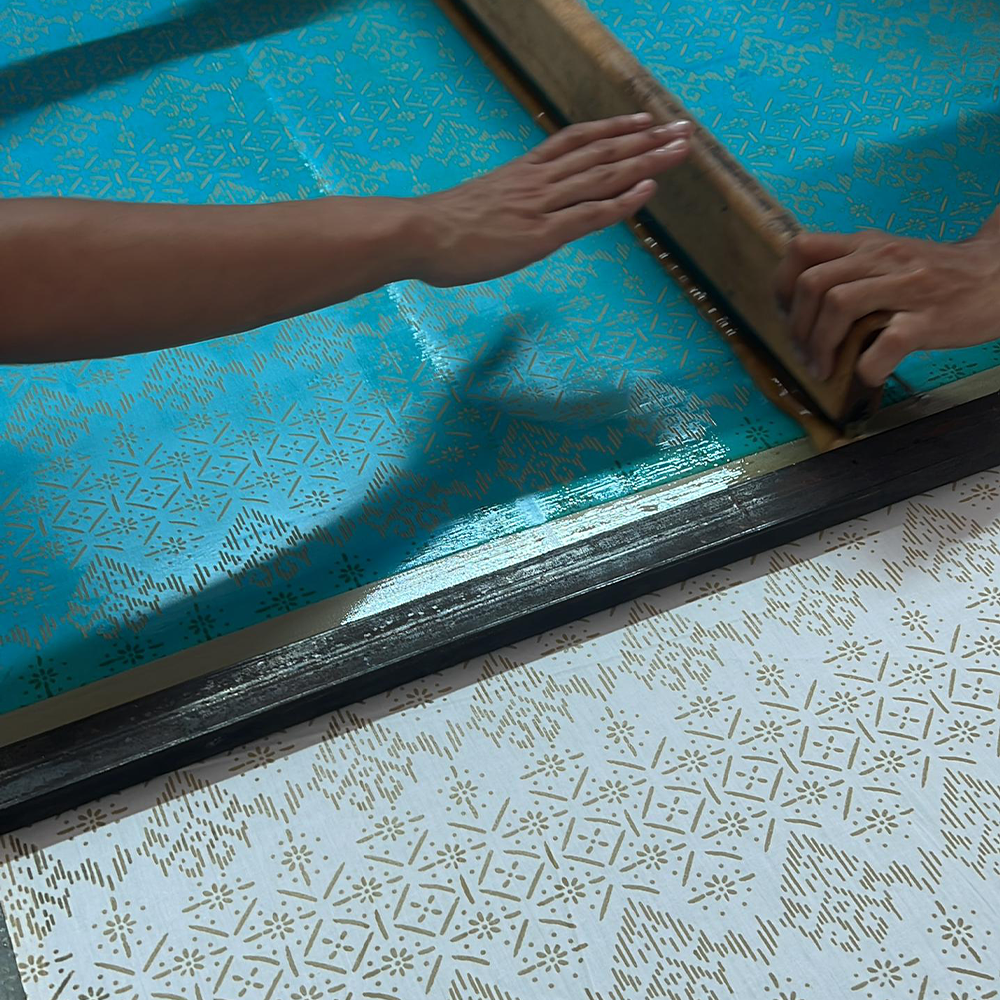 artisan in the process of pouring wax in batik process