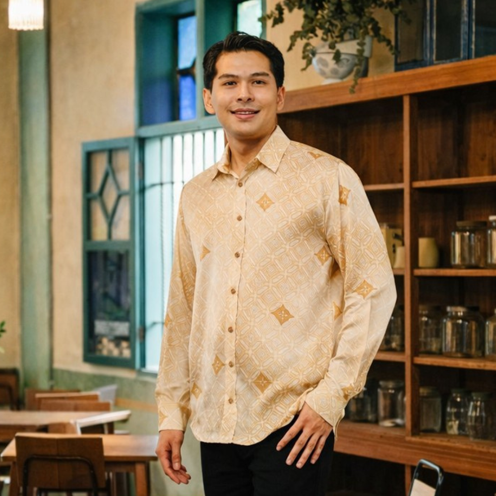 Man wearing a patterned beige shirt in a casual indoor setting