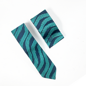 a whitebox photo of a neck tie and pocket square in the pattern teal snakeskin