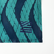 a closeup of embroidery against a white background in the pattern teal snakeskin