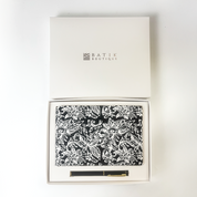 Batik Boutique gift set featuring black floral batik notebook and pen in white presentation box.