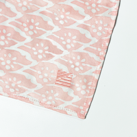 a closeup of batik scarf in the pattern peach bloom to showcase the embroidered detailing on the scarf