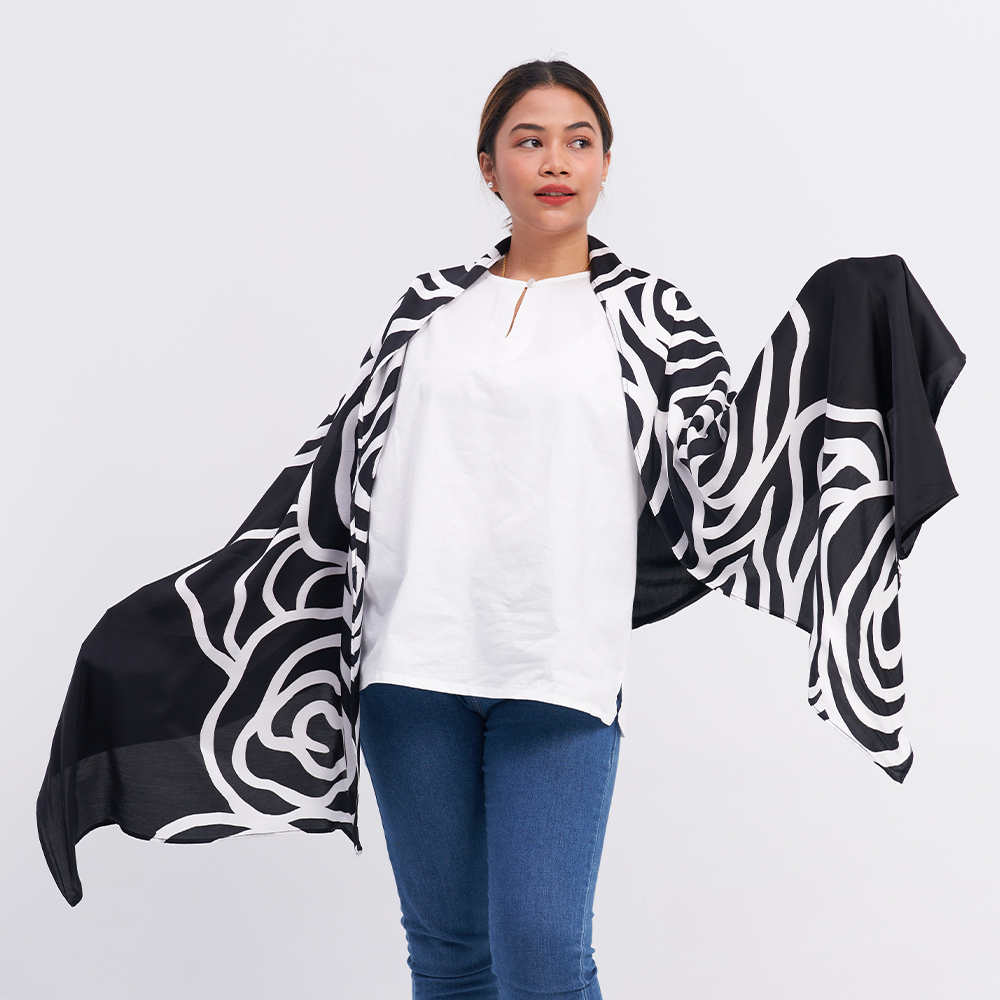 a woman posing with a batik scarf in the pattern black kerepek