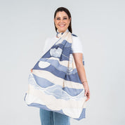 Woman wearing a large blue and white patterned scarf on a plain background