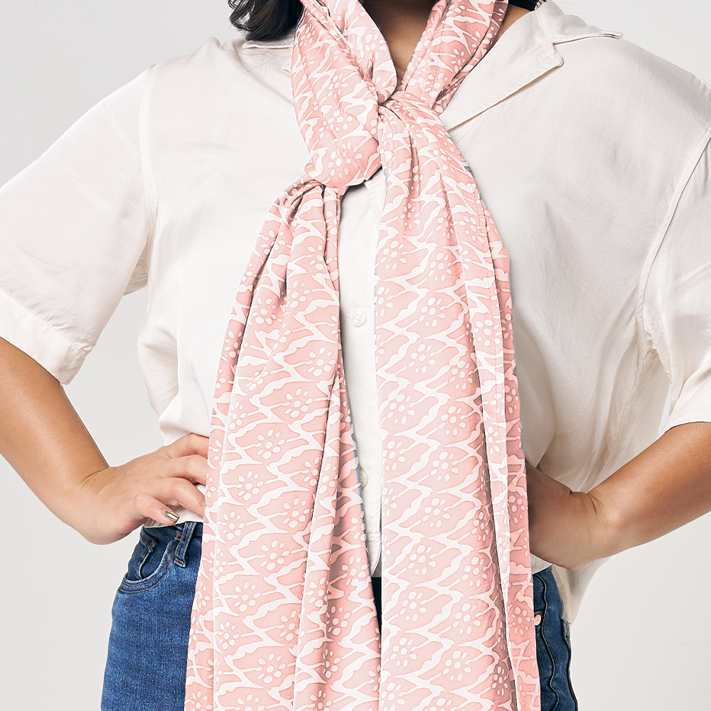 a model in a peach bloom batik scarf against a white background