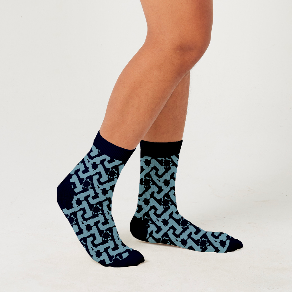 a model wearing a batik inspired socks in the best selling pattern midnight arabesque against the white background