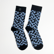 a batik inspired socks in the pattern midnight arabesque against a white background with embroidered logo