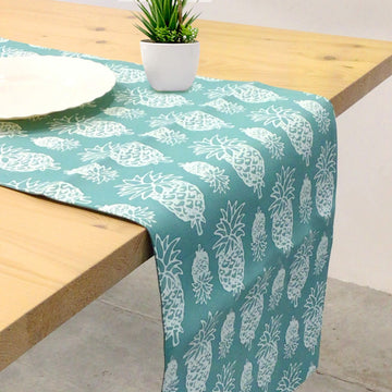 a table runner being displayed in a lifestyle photo with the pattern turquoise pineapple