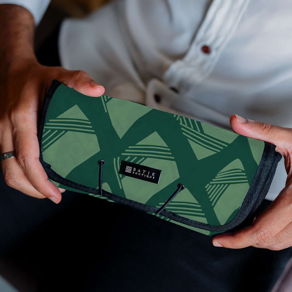 a model holding an authentic batik travel roll-up pouch in the pattern green nasi lemak