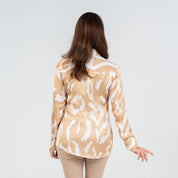 Back view of a woman wearing a long-sleeved batik shirt in Tan Rimba print, showcasing a flowy and breathable silhouette with a jungle-inspired motif