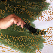 A photograph capturing an artisan engrossed in the traditional batik-making process, meticulously coloring the fabric.