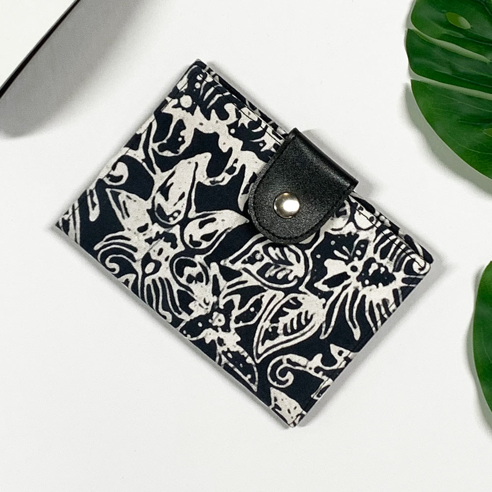 a lifestyle picture of a passport cover made of batik in the pattern black bunga made of batik