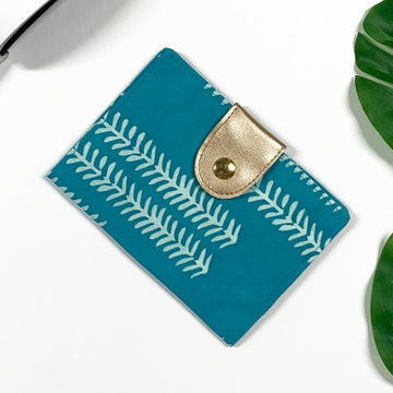 a lifestyle photo of a passport cover made of batik in the pattern mint arrow