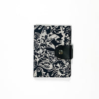 the front view of a passport cover made of batik in the pattern black bunga