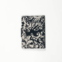 the back view of a passport cover in the pattern black bunga