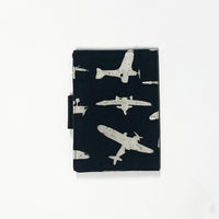 a back view of passport cover made of batik in the pattern black airplane