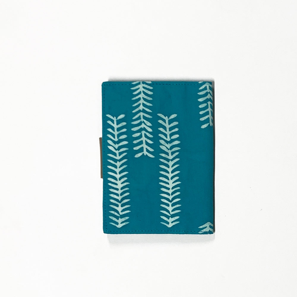 a photo showcasing the back side of a passport cover made of batik in the pattern mint arrow