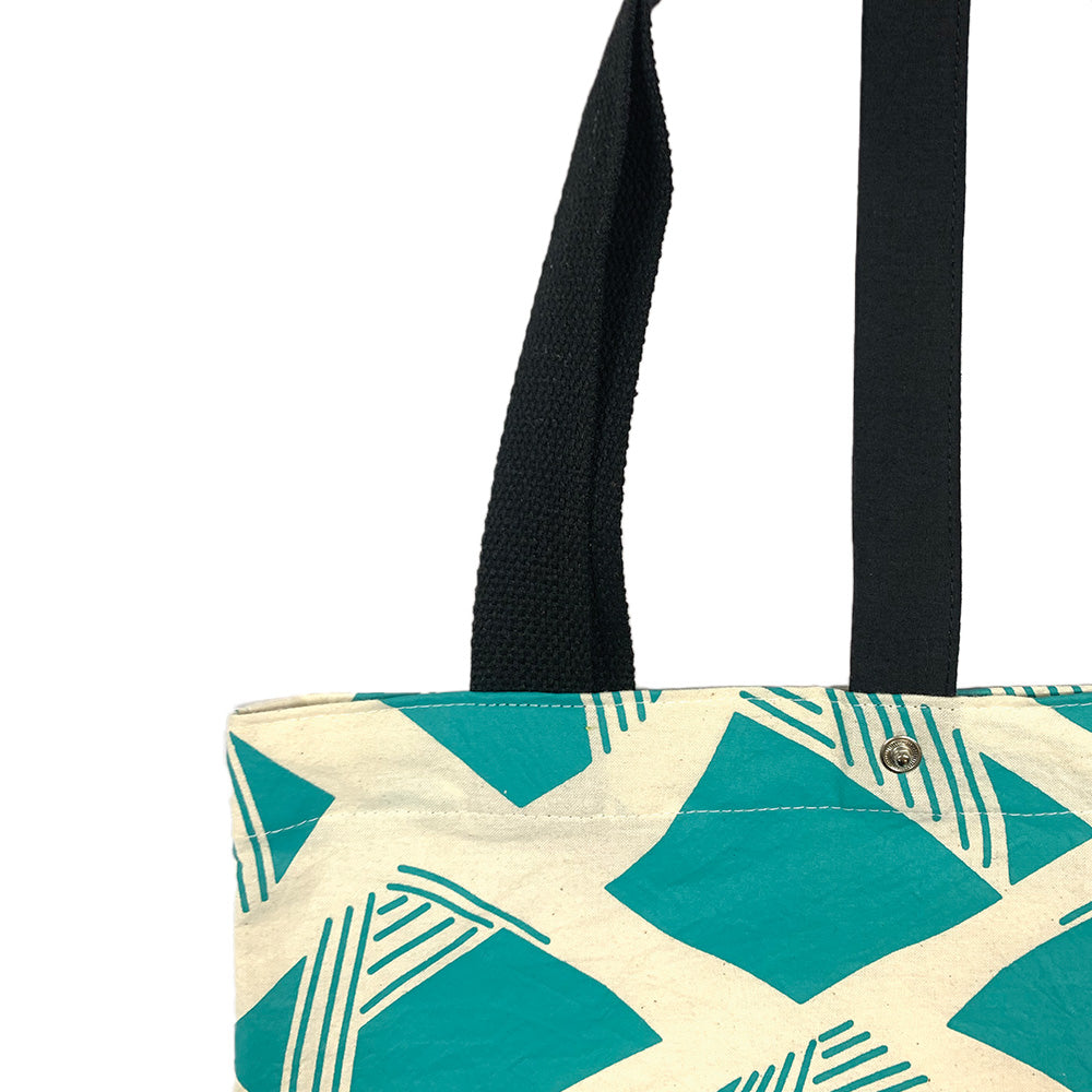 a close up of a batik tote bag in front of a white background in nasi lemak motif in the color turquoise