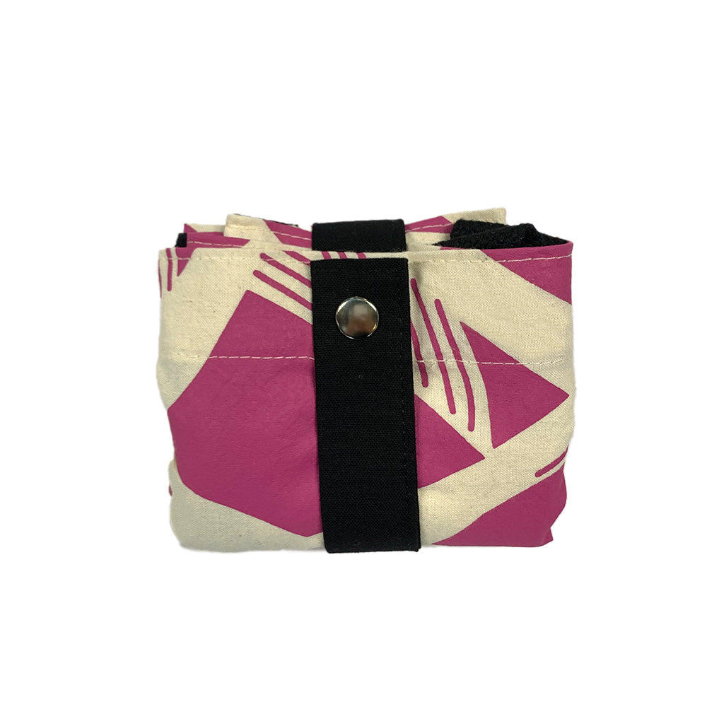 A batik totebag or even a shopping bag with pattern inspired from Nasi Lemak in fuchsia color and put on a white background. This photo show folded version of the bag.