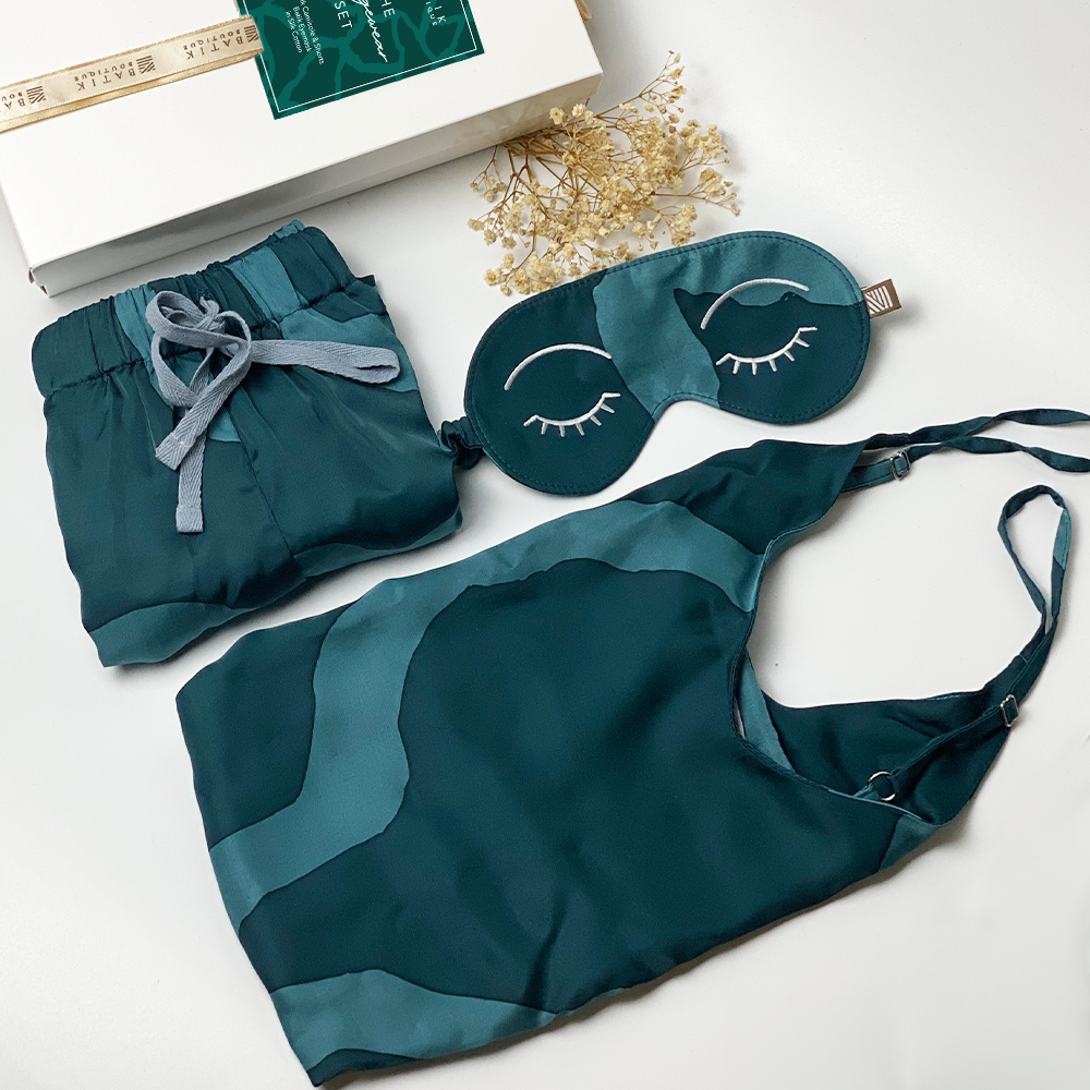 A lifestyle photo of batik loungewear set which consist of silk cotton camisole, shorts and eyemask in Forest Chain