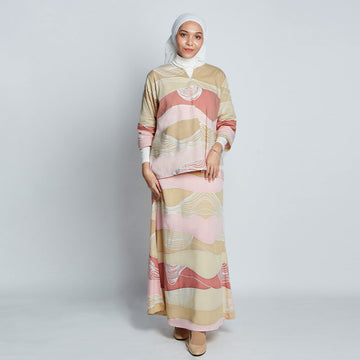 Full body view of a woman is wearing a batik baju Kedah and a batik long skirt in pastel colors.