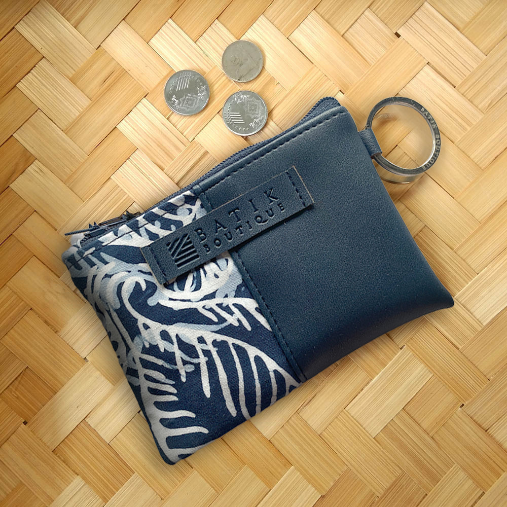 an upview lifestyle photo of card holder wallet with coins coming out of the wallet