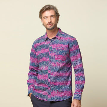 A photo of man standing in front of beige background wearing maroon long sleeved shirt facing front