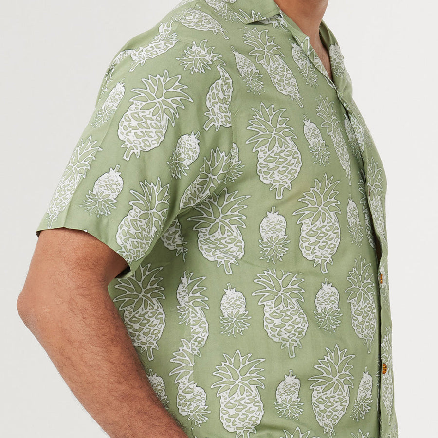 a close up photo of men shirt in olive pineapple pattern