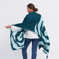 a female model posing with her back to the camera and a batik scarf in the pattern teal rose