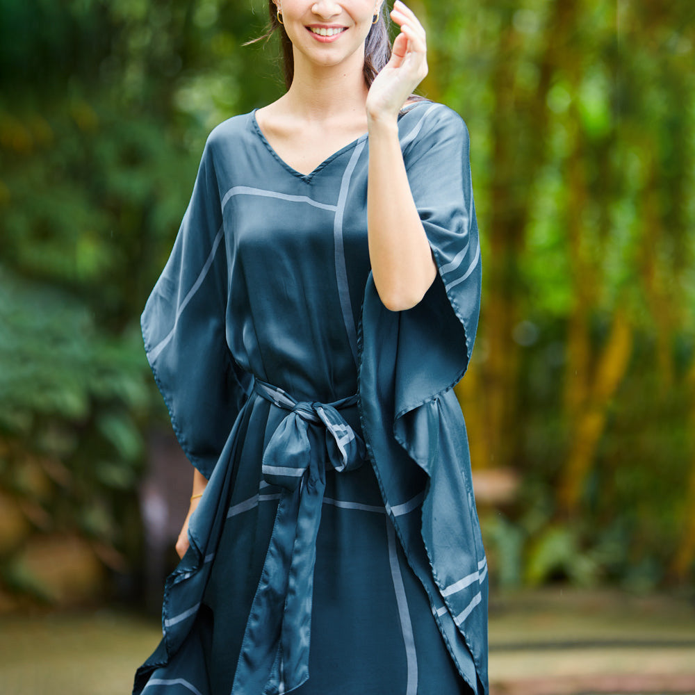 Woman at a Malaysian resort wearing batik Caftan Maxi Dress in forest green.  Edit alt text