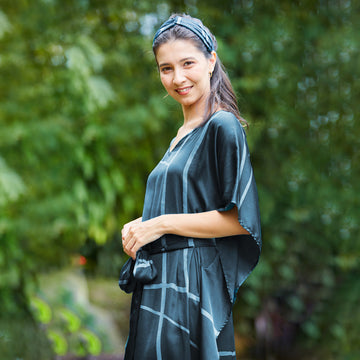 Woman at a Malaysian resort wearing batik belted Caftan Maxi Dress in forest green.  Edit alt text