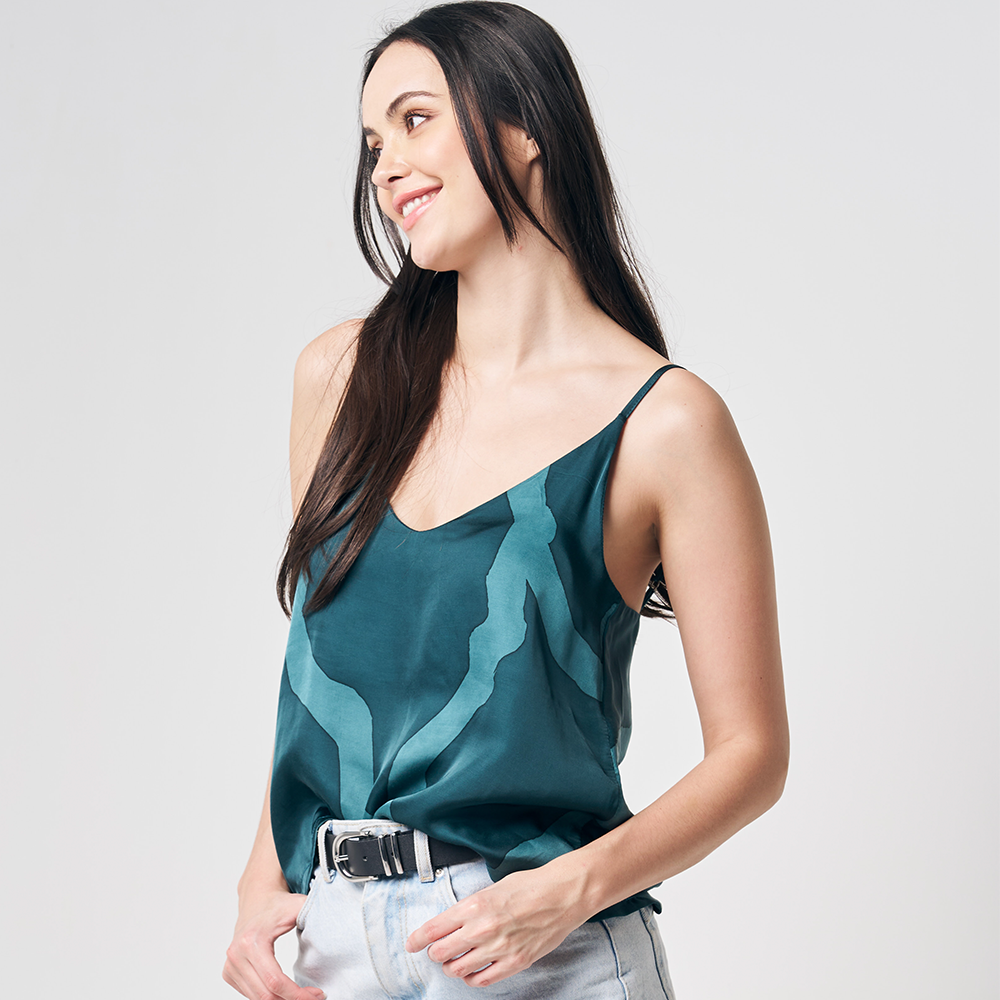 A model casting a gaze to the side while posing in a Forest Chain patterned batik camisole against a clean and neutral background