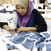 a photo of an artisan sewing and in the process of making batik dress