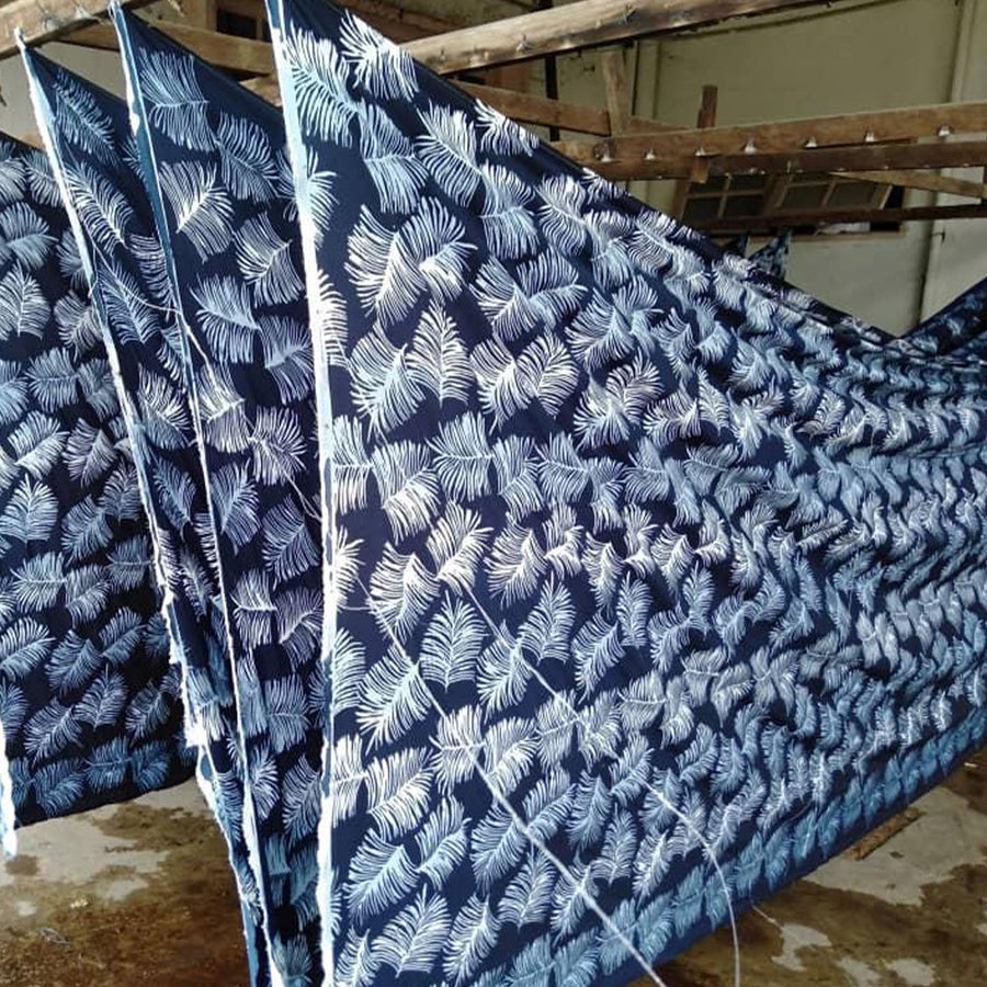 Artisans carefully hanging Navy Sawit patterned batik to dry