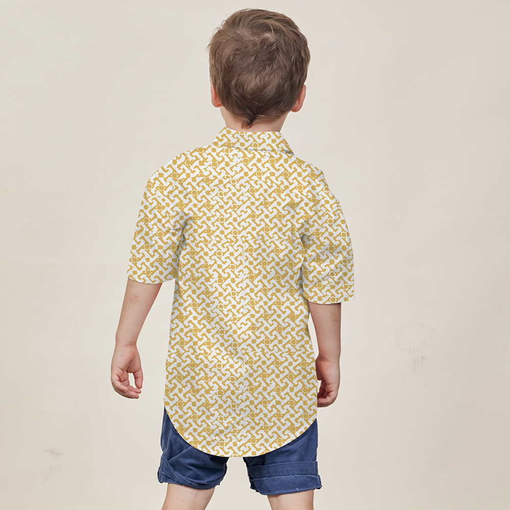 A young boy turned away from the camera, proudly showcasing the Mustard Arabesque patterned batik shirt