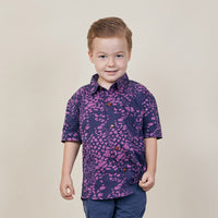A boy wearing batik shirt in purple bintik pattern