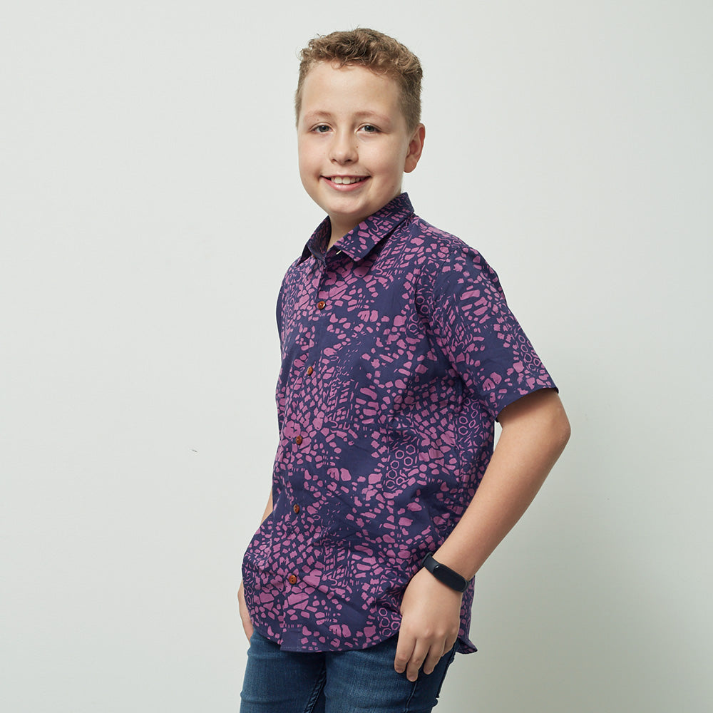 A boy wearing batik shirt in purple bintik pattern