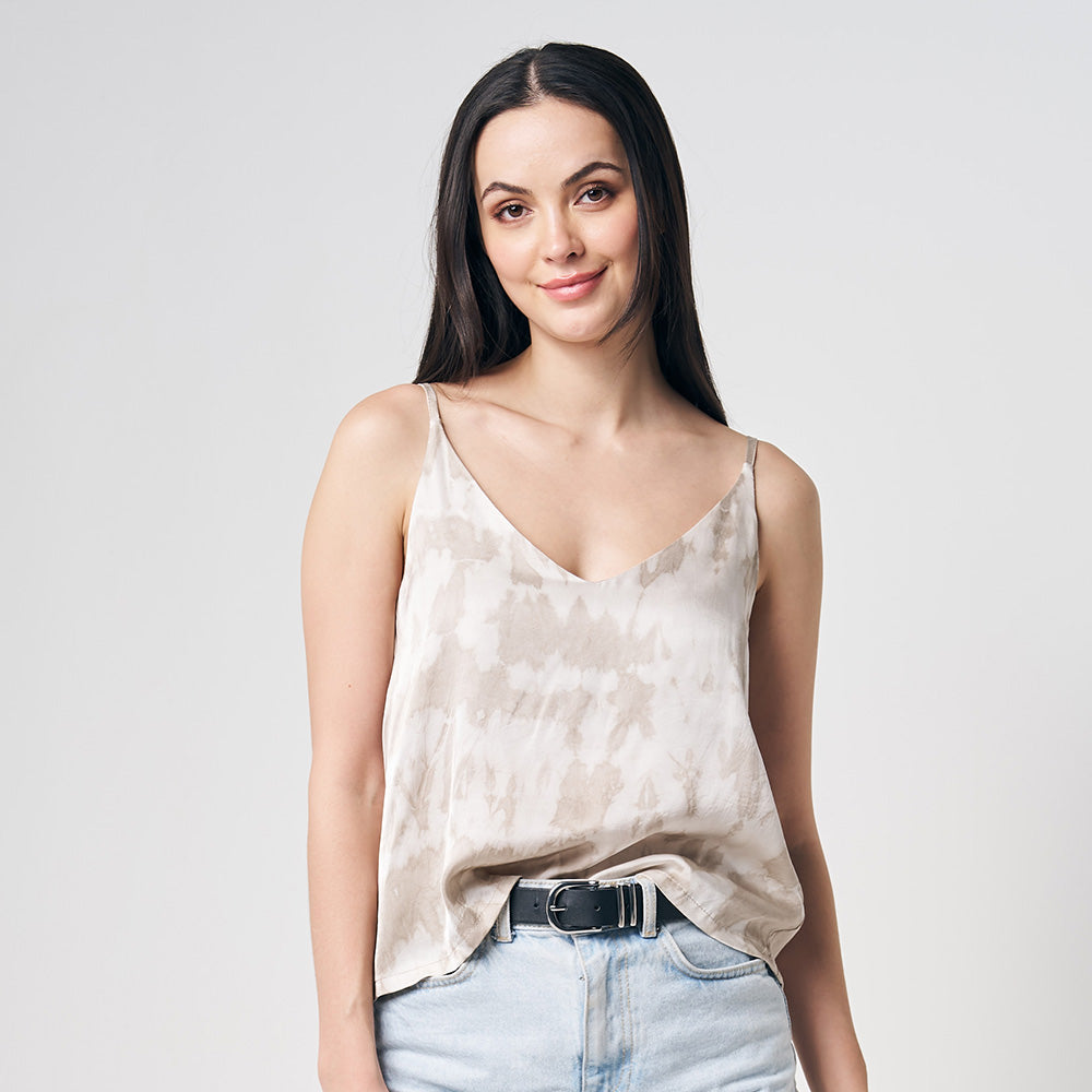 A model is wearing hand-made shibori v-neck camisole with adjustable strap while standing in front of white background