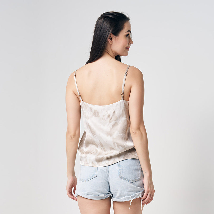 A model is wearing hand-made shibori v-neck camisole with adjustable strap while facing white background