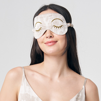 a woman posing with a shibori eye mask in the pattern mangosteen against a neutral background