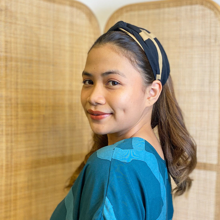 A woman is wearing batik headband in Black Ecru pattern made by remanant batik fabric for more sustainable approach