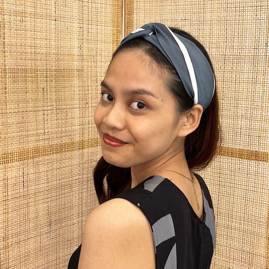 A model is wearing batik headband in grey brush print. Made from batik remnant fabric