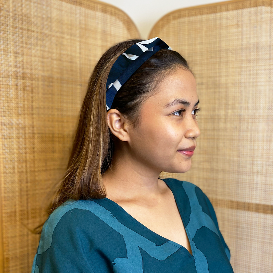 A model is wearing batik headband in navy brush print. Made from batik remnant fabric