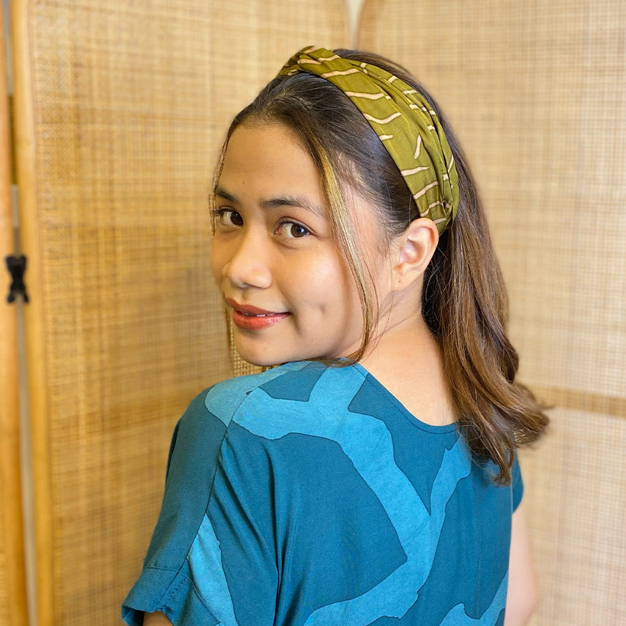 A woman is wearing batik headband in Moss Fern pattern made by remnant batik fabric for more sustainable approach