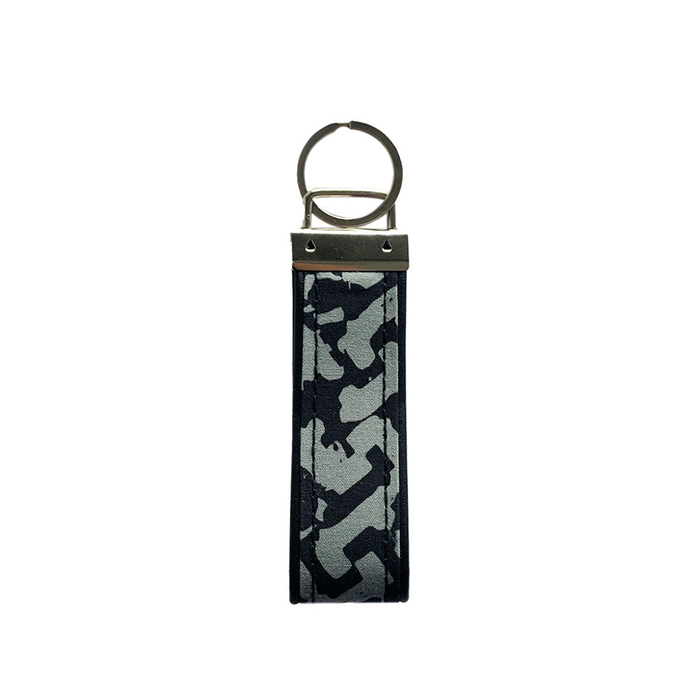 A backside photo of batik key fob in grey arabesque on a white color background