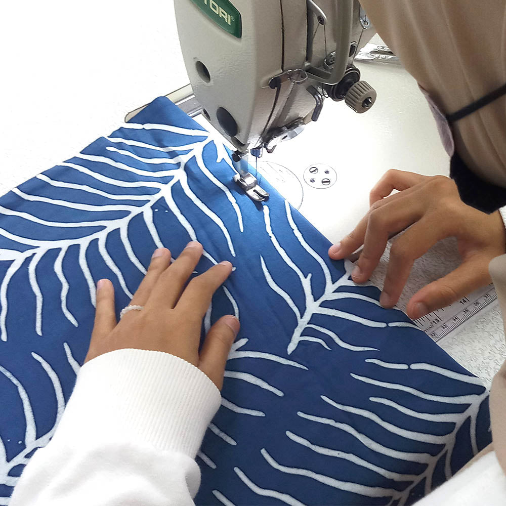 Batik artisan operating at the sewing machine, handsawn in Malaysia.