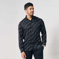 A man is wearing batik long sleeve shirt in Jet Tangga, black color shirt. While posing in front of white background